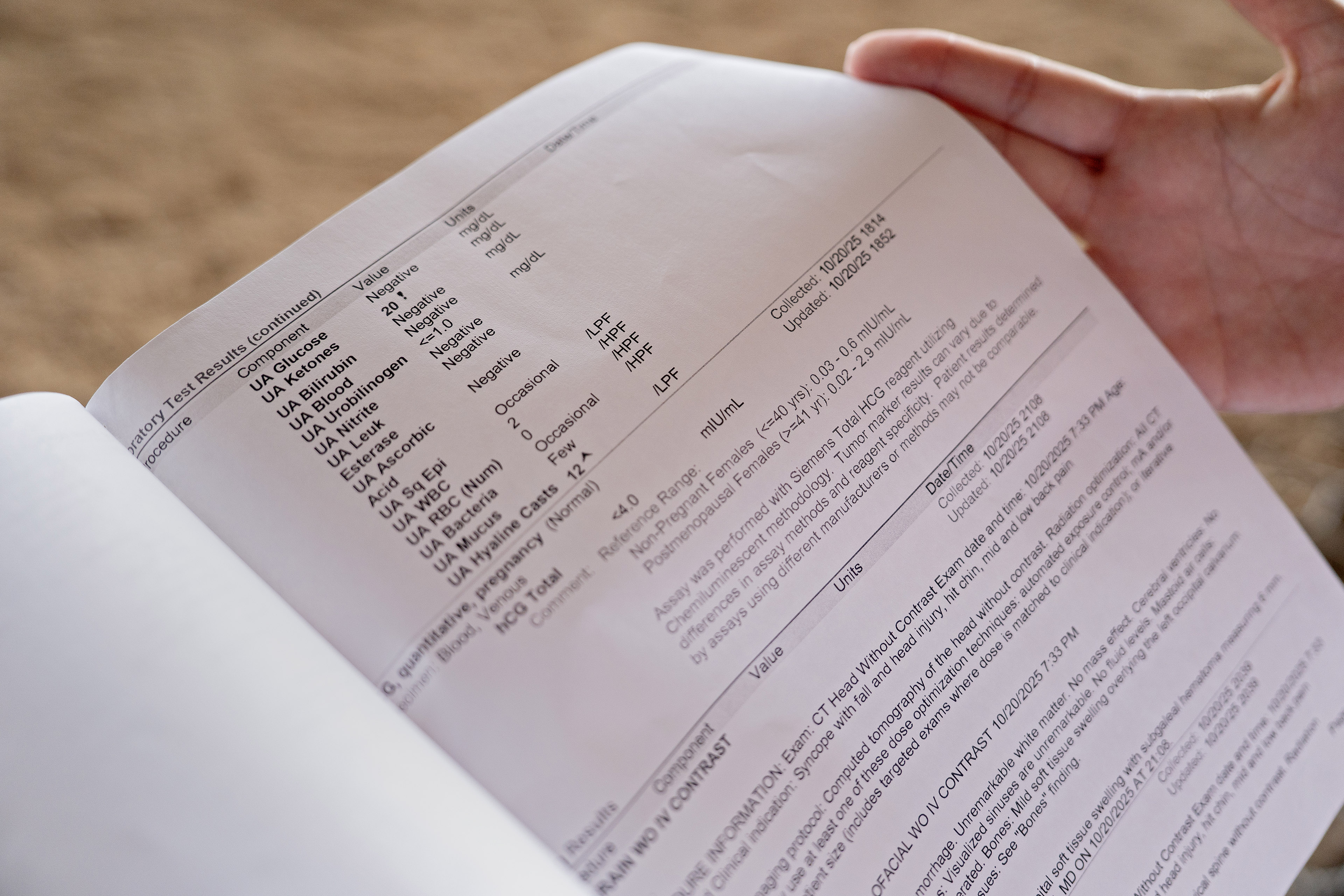 A hand holds a piece of paper with lab results
